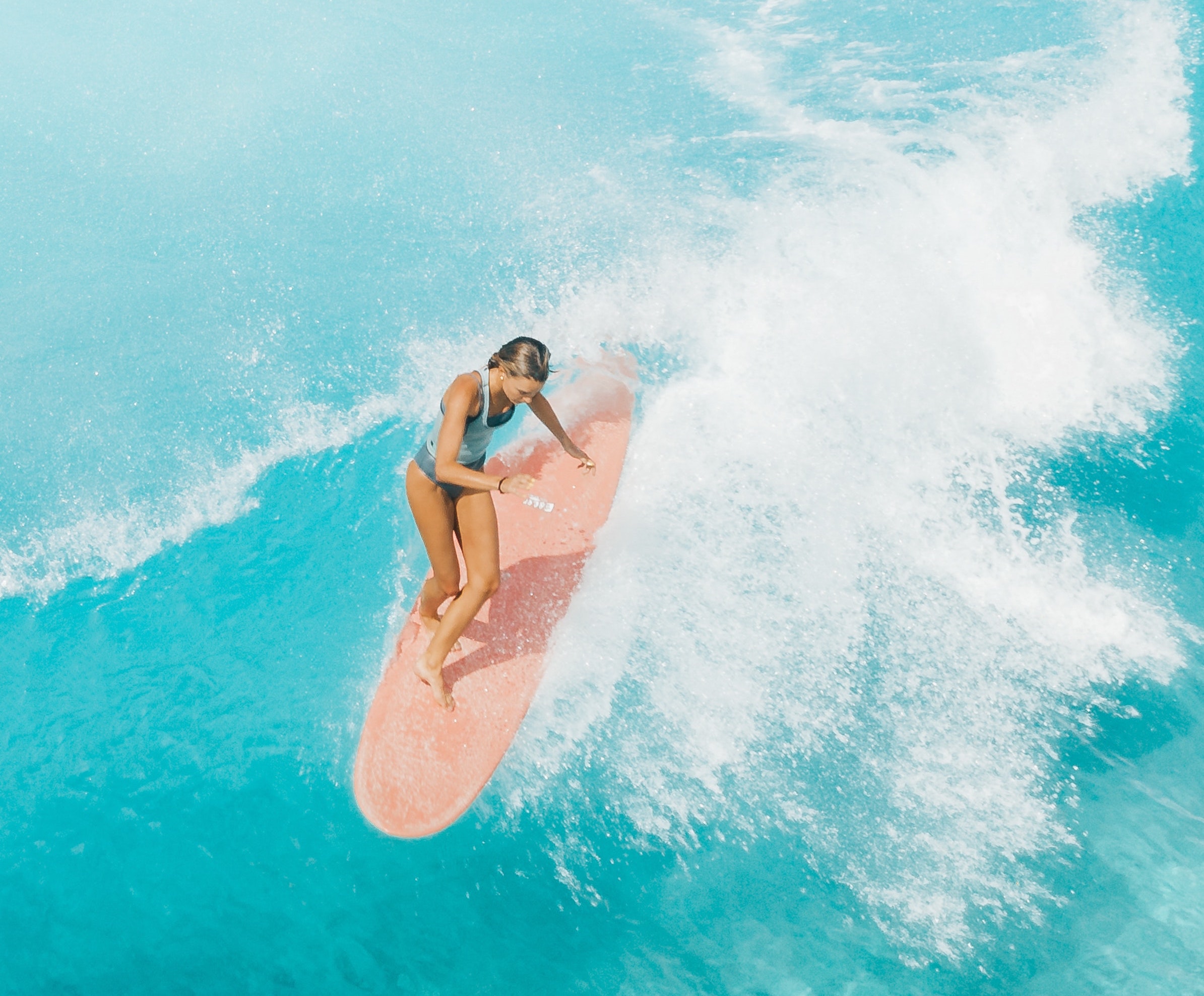 A girl catches a wave, or nalu, while surfing in Hawaii, photo © Jess Loiteron for pexels.com