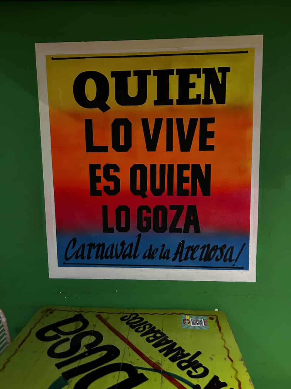 A colorful poster reads, "Quien lo vive es quien lo goza" - those who live are those who party, in Barranquilla, Colombia, photo ©Kate Dana