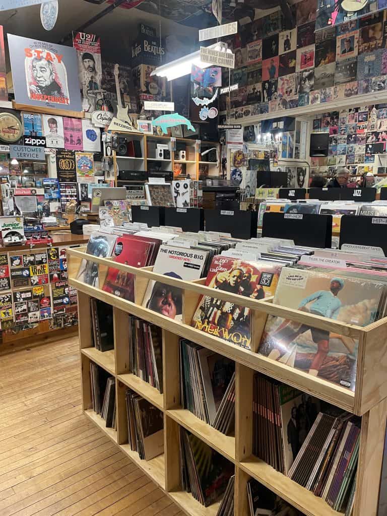 Colorful crates and shelves of vinyl records, CDs, and 45s fill the space beside busy walls covered in stickers, posters, and other memorabilia for music lovers shopping at Boo Boo records, in San Luis Obispo California photo © Kate Dana