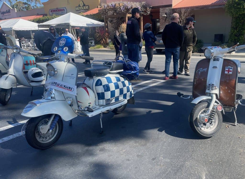 A small group of enthusiasts and owners of Lambretta and Vespa vintage Italian motor scooters gather for coffee outside of the Nautical Bean in San Luis Obispo, CA, for the annual Rides of March scooter rally, with two Lambretta scooters in the foreground, photo ©Kate Dana