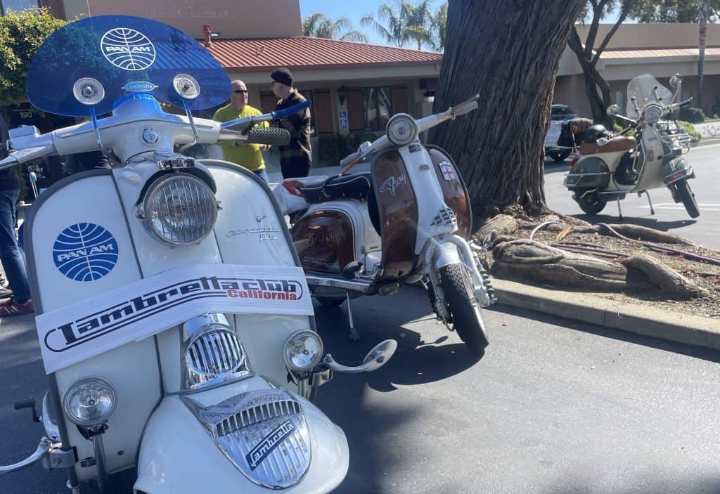 Vintage Lambretta and Vespa Italian motor scooters parked together in a lot in San Luis Obispo, CA, for the annual Rides of March scooter rally, with two Lambretta scooters in the foreground, photo ©Kate Dana