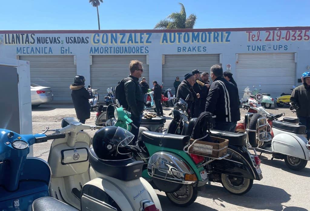 A group of riders of vintage Lambretta and Vespa Italian motor scooters stop with their bikes for fuel and service in Guadalupe, CA, along the daytime ride route for the annual Rides of March scooter rally held in San Luis Obispo, CA, photo ©Kate Dana