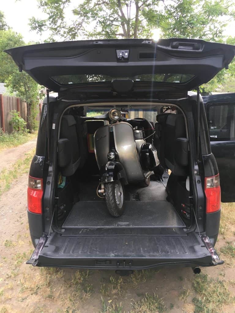 A vintage Vespa, an Italian motor scooter, is loaded into a black Honda Element with the seats removed, ready for transporting the weekend of the annual Rides of March scooter rally in San Luis Obispo, CA, photo ©Kate Dana