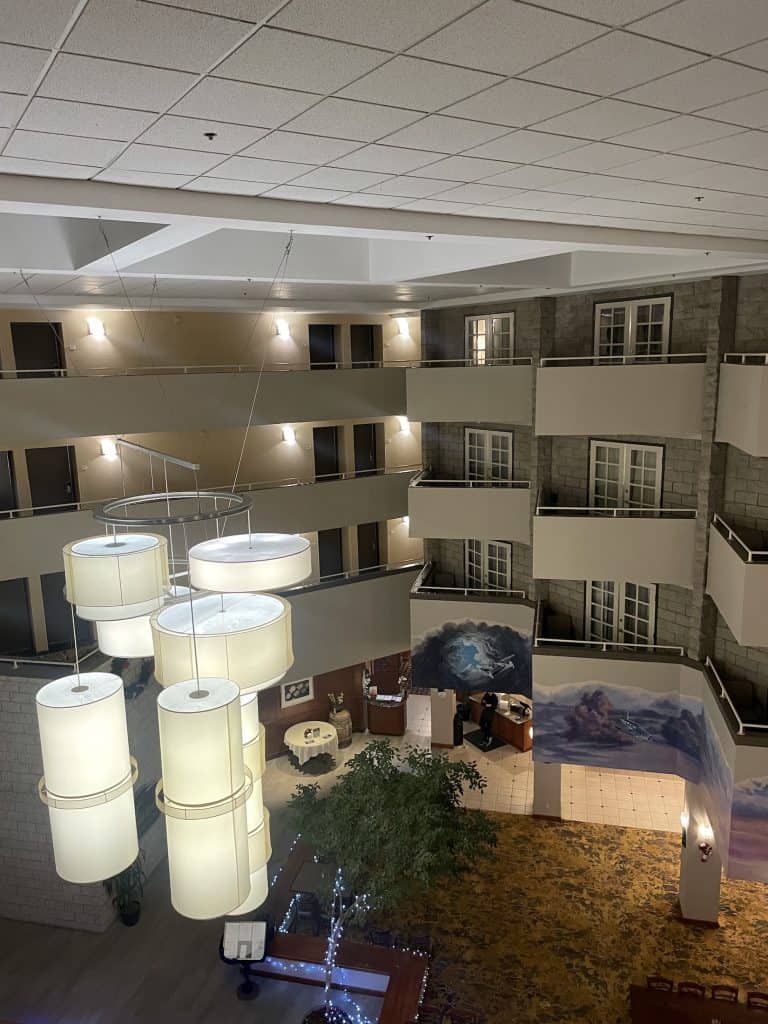 Large, clear white lamps hang from the 3rd floor in the open, modern lobby of the Radisson Santa Maria in the Santa Maria Valley, CA, photo © Kate Dana