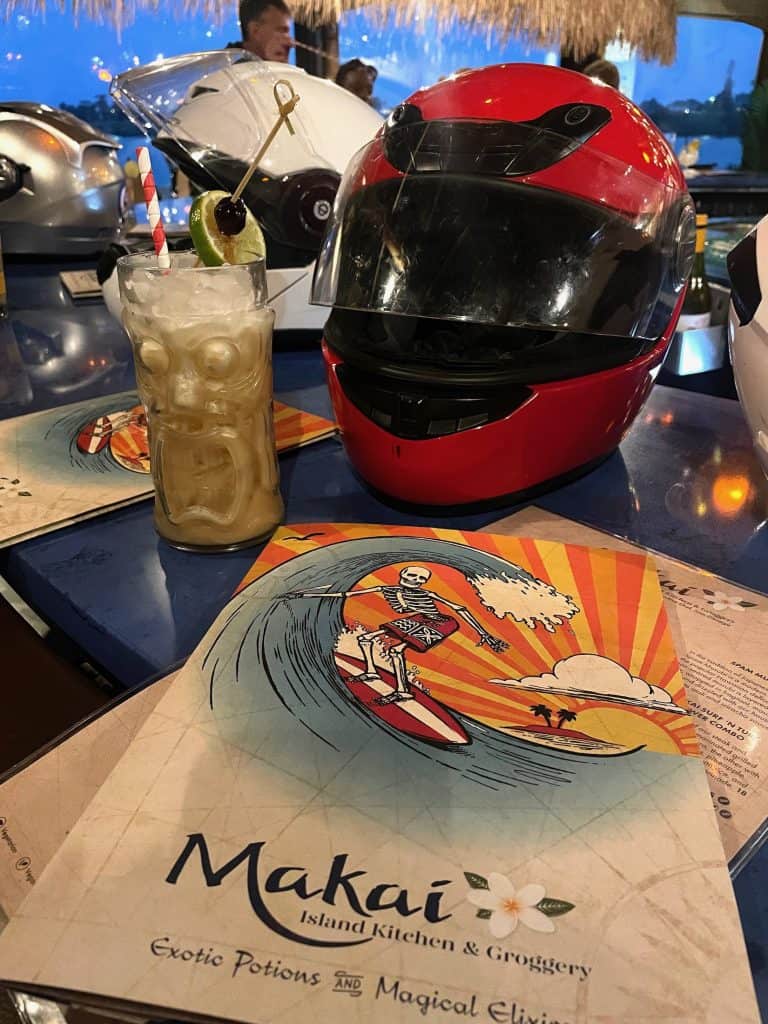 Motorcycle helmets line the bar next to tropical cocktails at Makai Island Kitchen and Groggery on the Municipal Wharf in Santa Cruz, CA during the Morning Wood Classic Scooter Weekend. photo ©Kate Dana