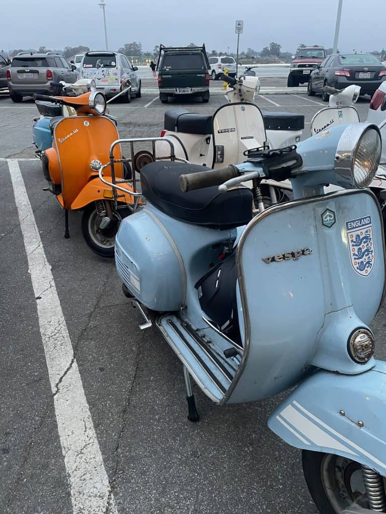 Colorful, vintage scooters parked in a group on the beams of the the Municipal Wharf in Santa Cruz, California during the two days of Morning Wood Classic Scooter Weekend photo ©Kate Dana