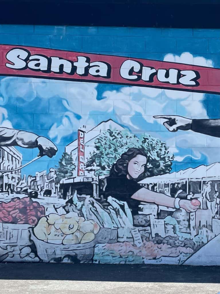 A hand painted mural in black, white, blue and red showcases the community and Farmers Market of Santa Cruz, CA in this photo for 45 California Sayings to Get Stoked About Right Now, photo © Kate Dana