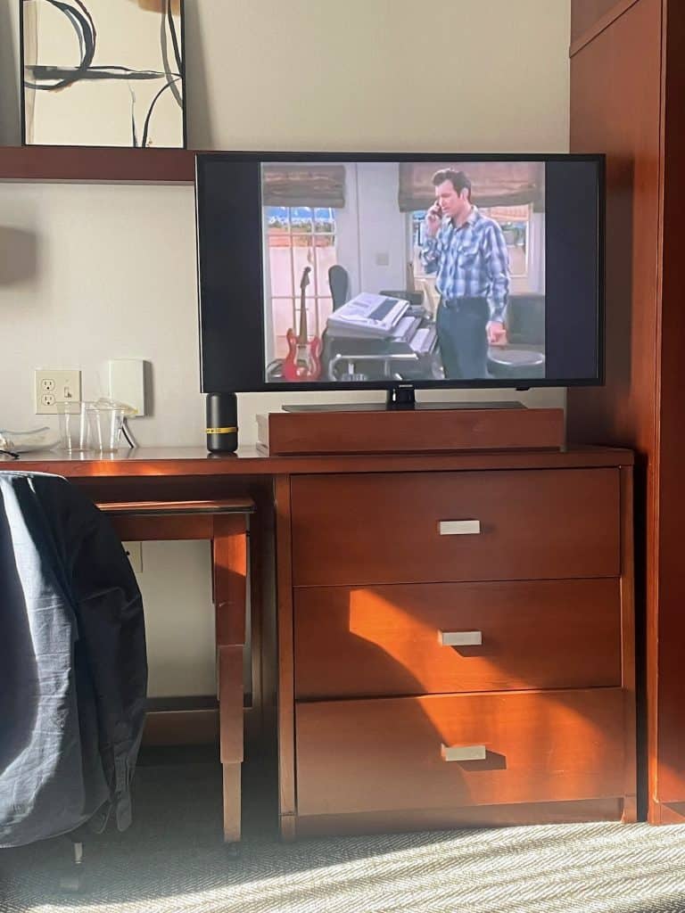 An episode of the Chris Isaak show plays in color on a television inside a hotel room in Long Beach, CA, location of the Long Beach Classic Scooter Club's annual Classic Not Plastic Scooter Rally on Memorial Day weekend, photo ©Kate Dana