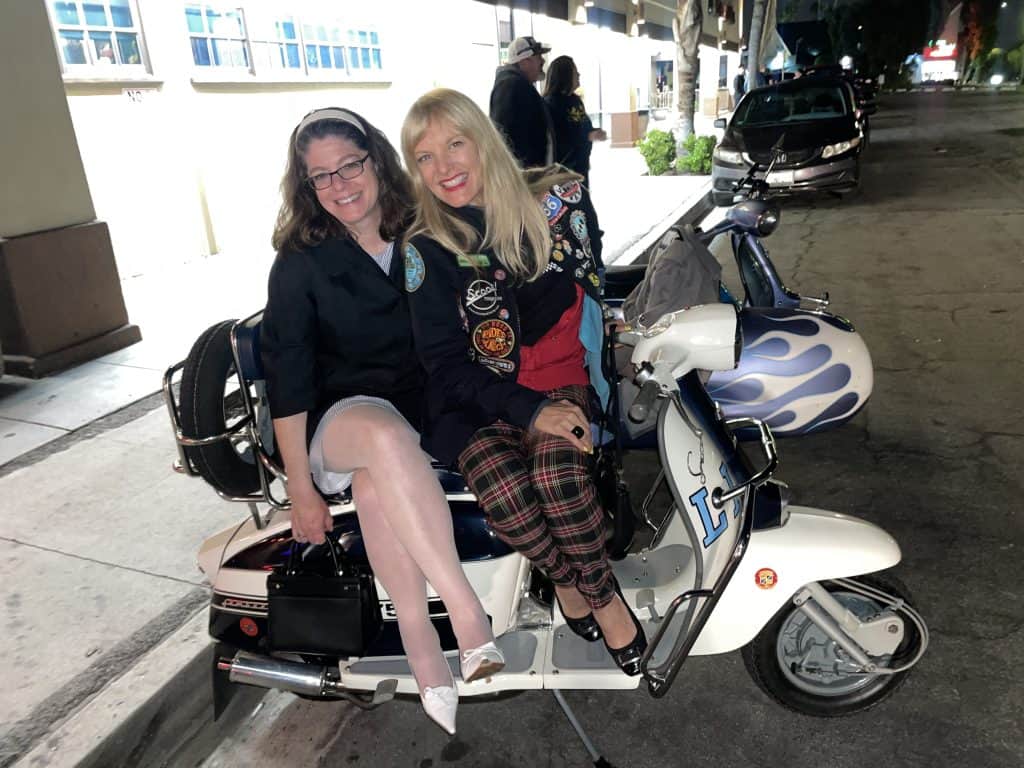 Two stylish girls sit side by side on a vintage Lambretta, photo ©Kate Dana
