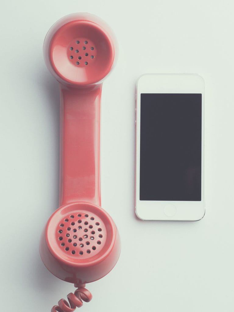 "Let me let you go": Two phones, a vintage pink handset with coiled cable and a modern, handheld cellular model, are side by side in this color, close-up photo for 78 Southern Phrases to Blow Your Hair Back, Cocameca.com photo © Canva