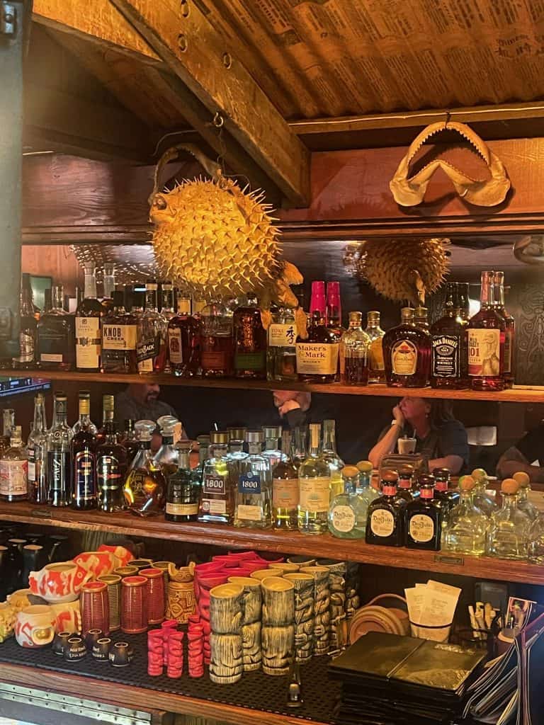 A taxidermic blowfish hangs from the ceiling next to a small shark jaw mounted to the wall near a vintage Tiki Bar at Trader Vic's restaurant inside the Atlanta Hilton hotel in Atlanta, GA, photo ©Kate Dana