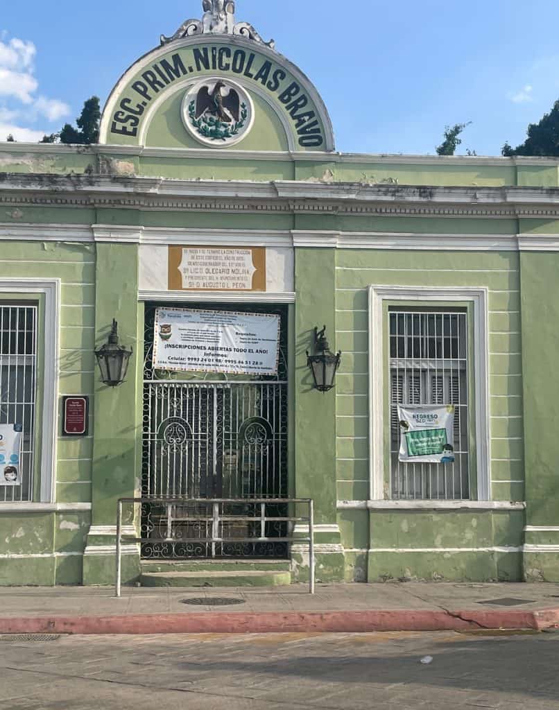 The lime green stone facade of a single-story building announces Escolar Primeria Nicholas Bravo in Merida, Mexico, photo ©Kate Dana