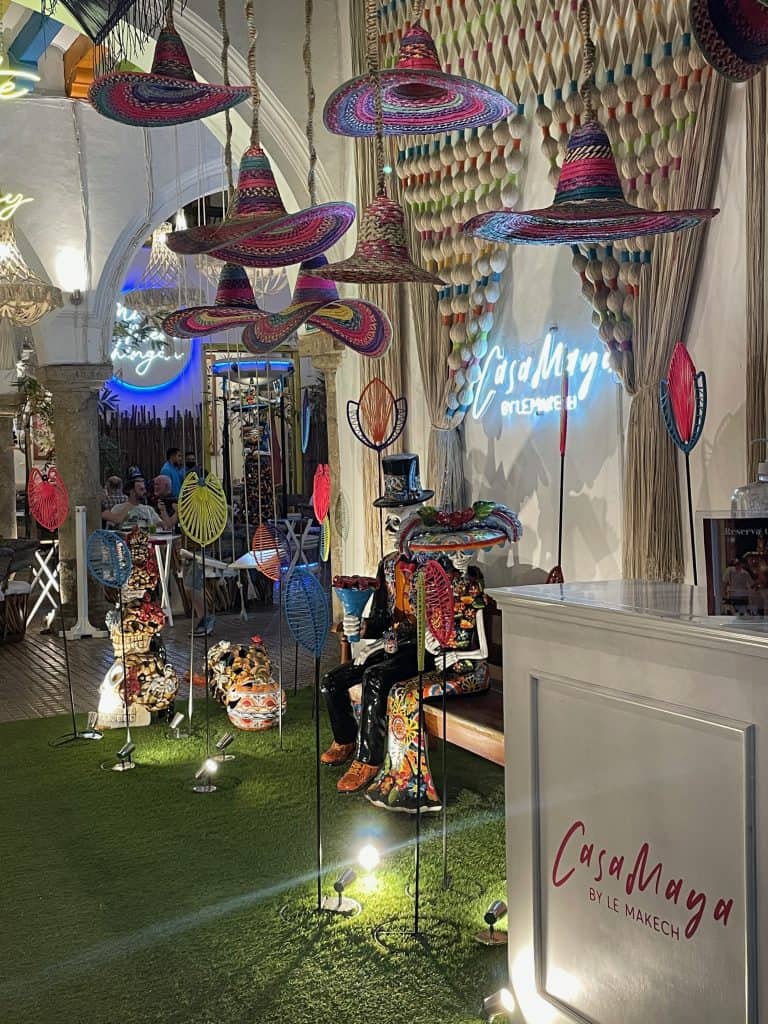 Colorful, hanging hats swing from the ceiling next to lamps and clay figures welcoming guests to Casa Maya Restaurant in Merida, Mexico ©Kate Dana