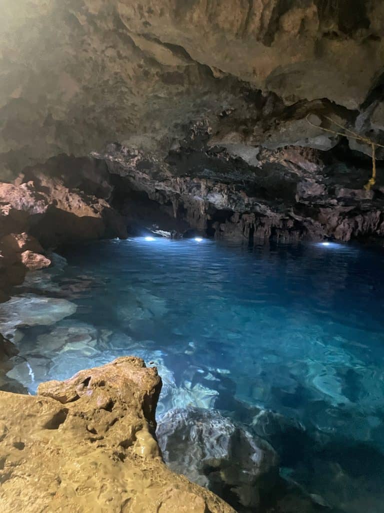 Bright, underwater lights illuminate the stones and blue water of a mineral cenote near Merida, Mexico ©Kate Dana