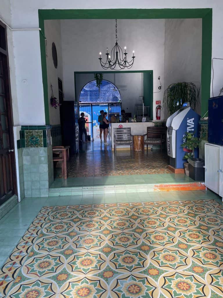 Colorful blue and yellow ornate Spanish tiles line the foyer welcoming guests into Che Nomadas hostel in Merida, Mexico, photo ©Kate Dana