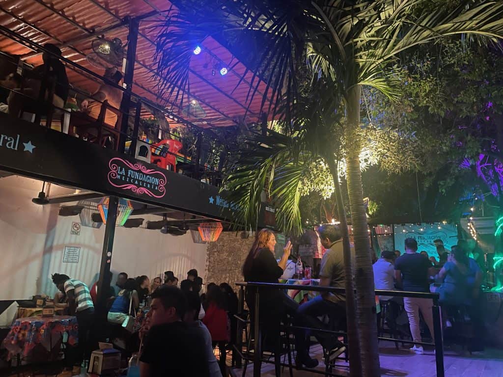Disco lights and club patrons enjoy the ambiance of the back patio at La Fundación Mezcalaria in Merida, Mexico, photo ©Kate Dana