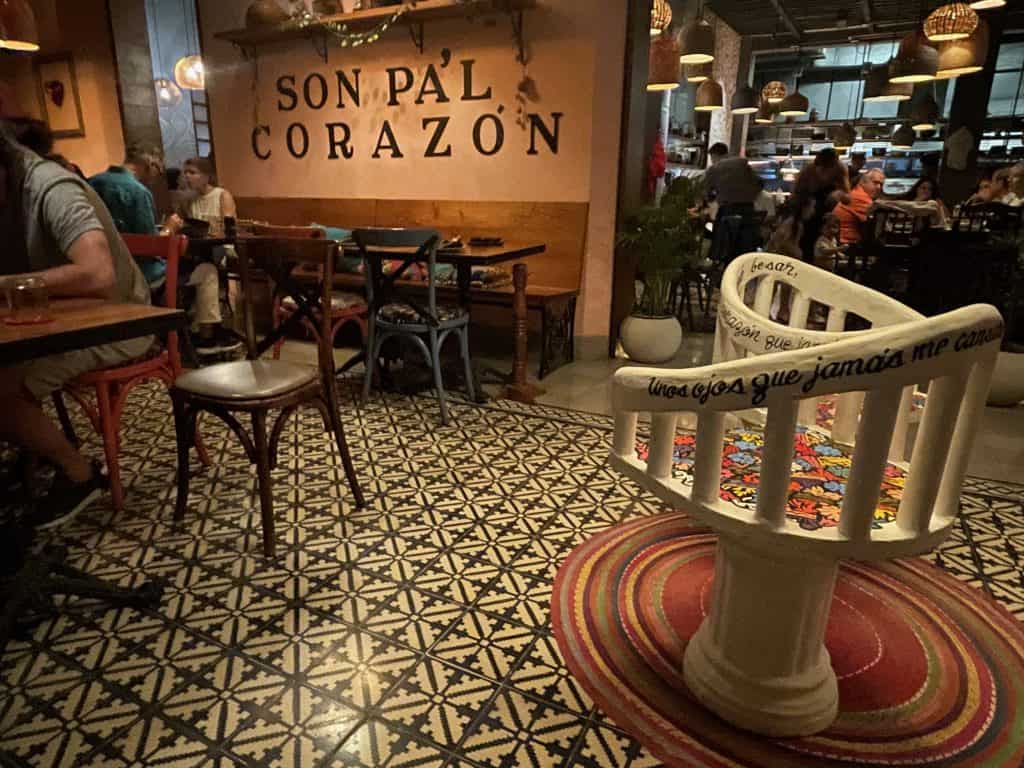 A wall graphic reads "Son Pa'l Corazón next to patterned floor tiles in the restaurant Micaela in Merida, Mexico, photo ©Kate Dana