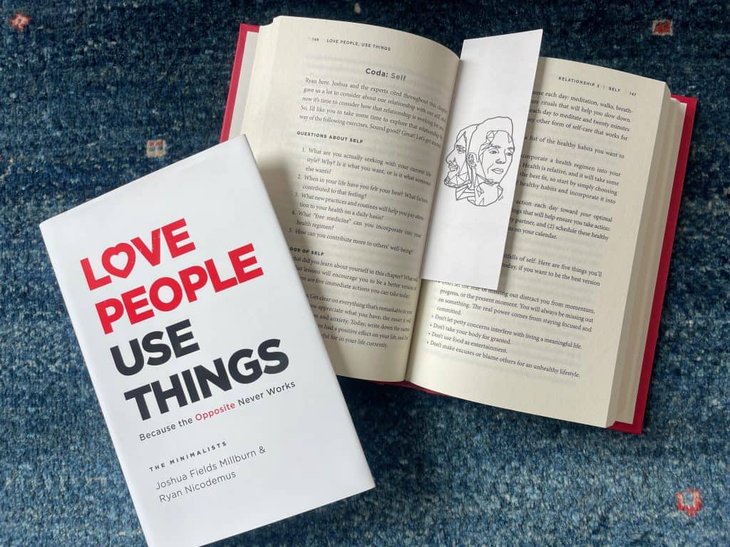 An open copy of Love People Use Things by Joshua Fields Millburn and Ryan Nicodemus with a paper jacket cover to the side, photo ©Kate Dana