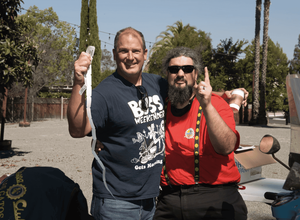 Vespiti two people celebrate raffle winnings with tickets at Vintage Vespa Days 2021, photo ©Dan Ciccone