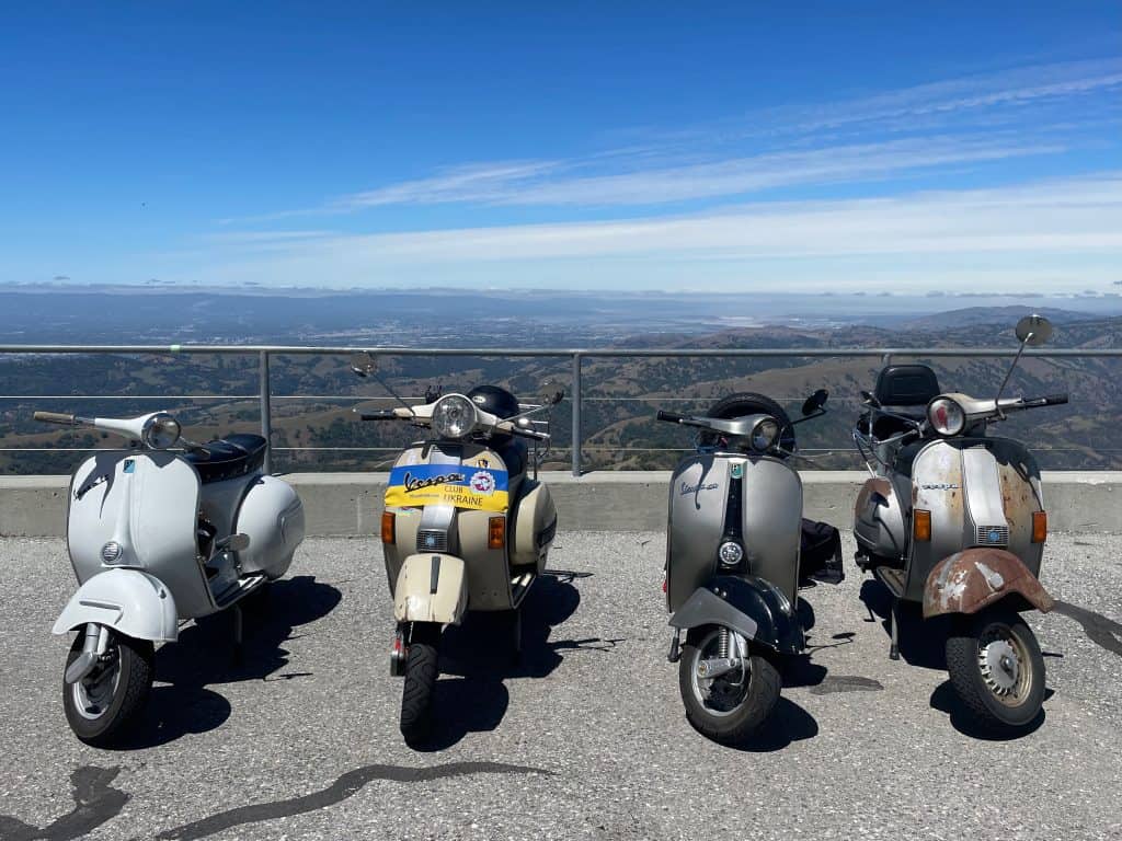 Vintage Vespas line up by the Lick Observatory with a overlook view of the San Jose mountains during Vintage Vespa Days 2022 in Los Gatos, CA, photo ©Kate Dana