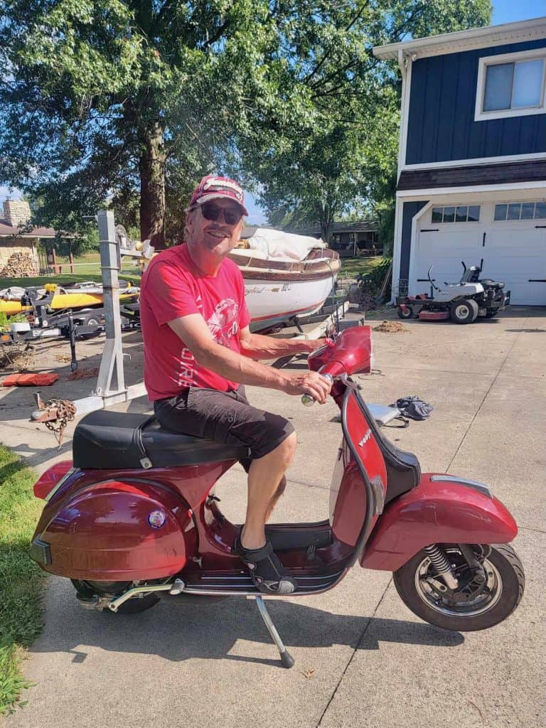 Burke Sandman of Vespa Shelbyville in Indiana sits on the red P200 he won during West Coast Vintage Vespa Days 2023, photo ©Kate Dana