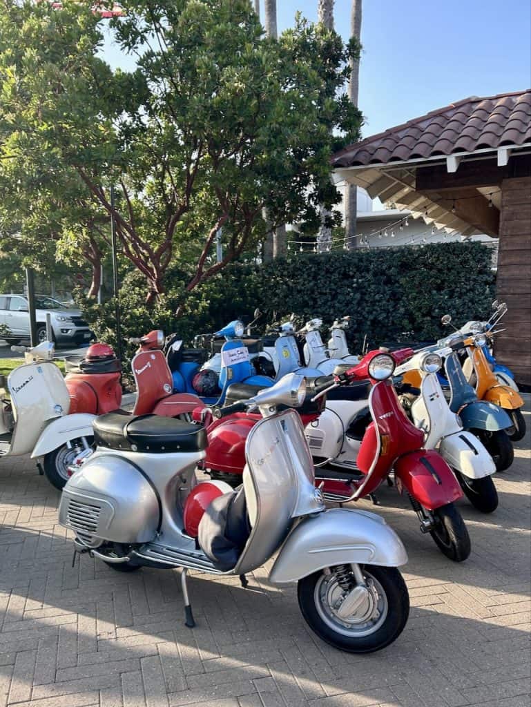 A group of colorful vintage Vespa scooters outside the Leta Hotel in Goleta, CA for West Coast Vintage Vespa Days, photo ©2024 Kate Dana