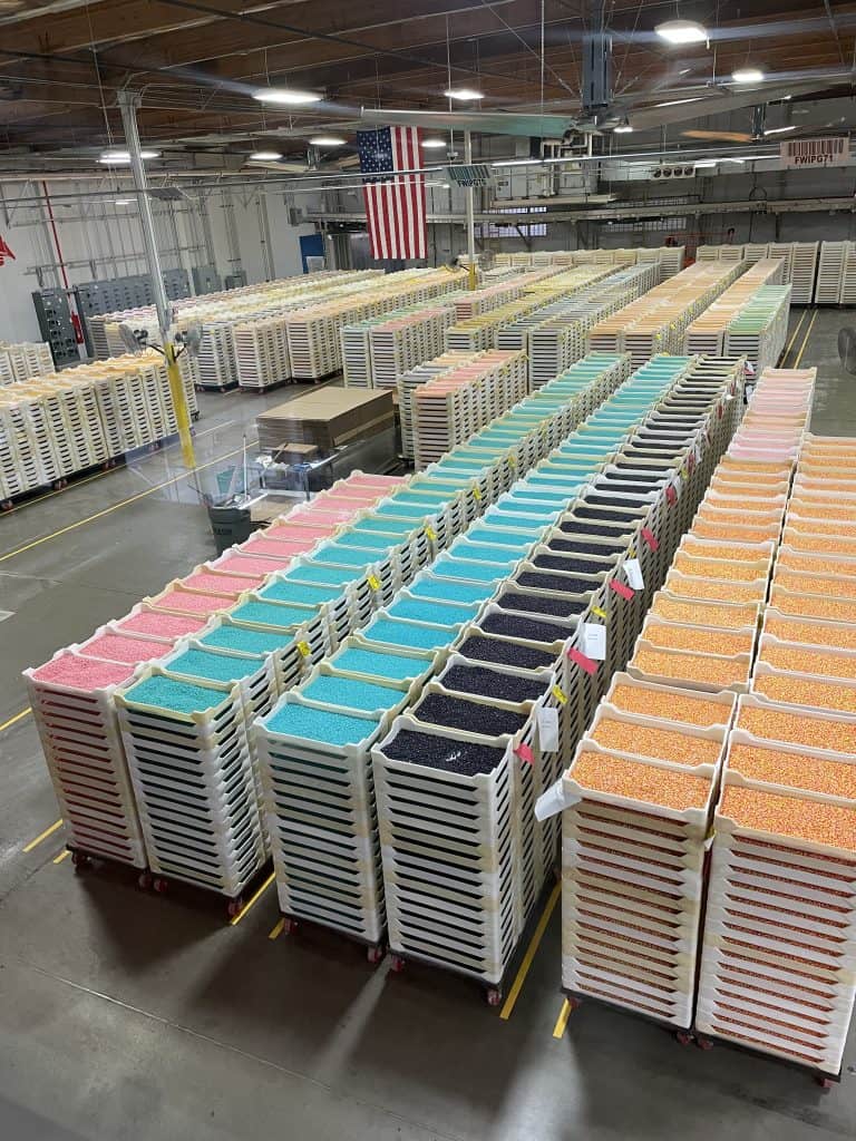 Large colorful palettes of Jelly Belly candies in pink, aqua, purple, and orange, stacked up several feet high, line the floors of the Jelly Belly Factory in Fairfield, CA, photo ©Kate Dana