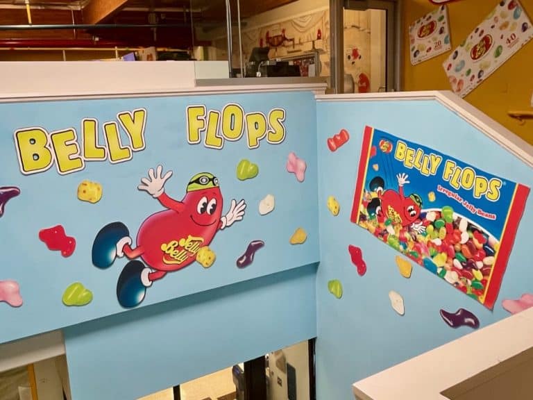 A graphic of Mr. Jelly Belly fllying along the wall near bags of Belly Flops inside the Jelly Belly Factory in Fairfield, CA, photo ©Kate Dana