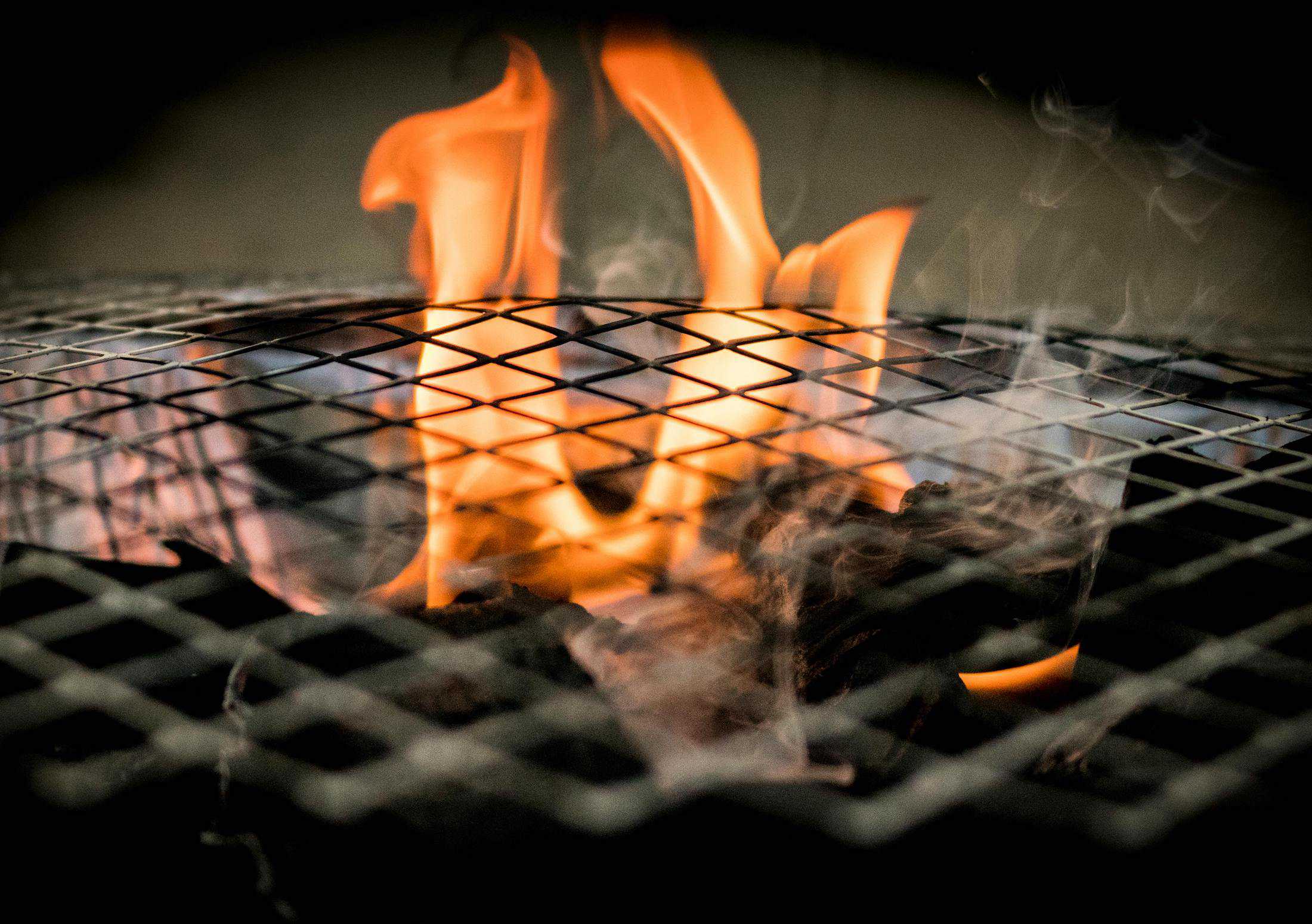A flame rises up on a dark grill, photo © Mateusz Dach for Pexels