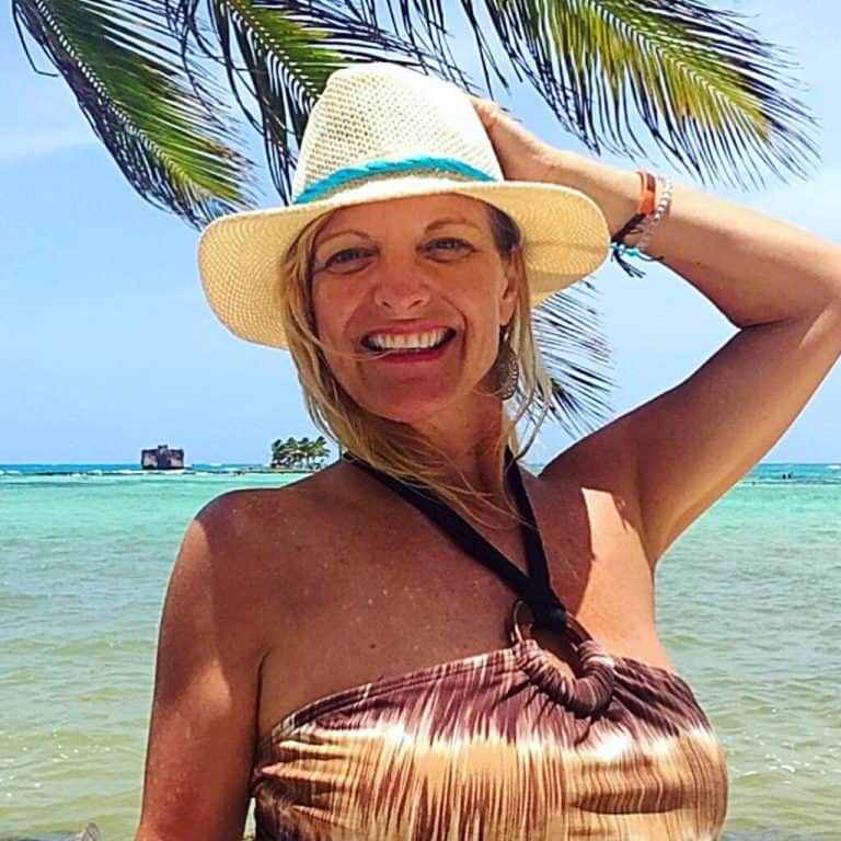 Cocameca founder Kate Dana smiles wearing a swimsuit and hat on a beach in Isla San Andrés, Colombia, photo ©Kate Dana