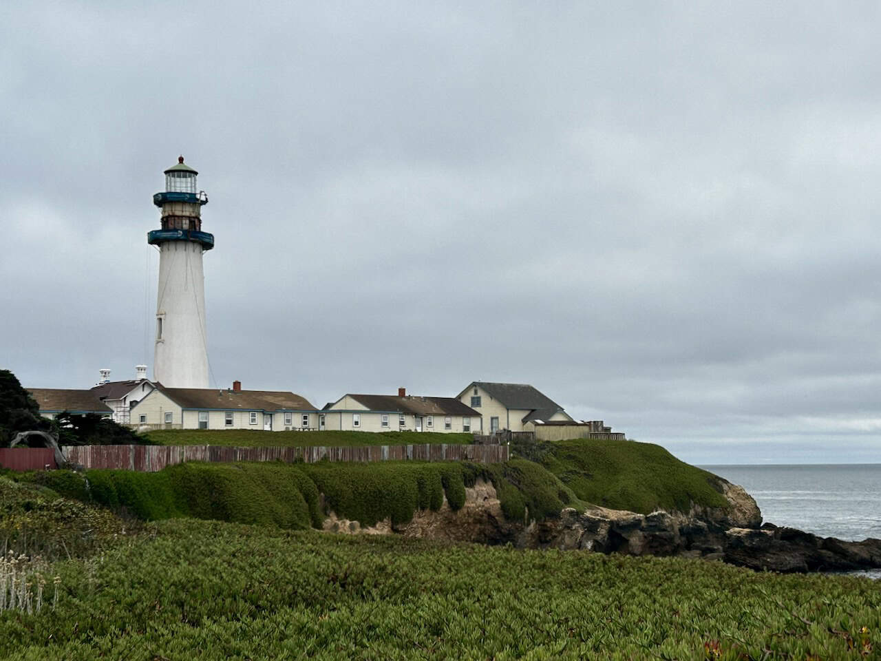 Pigeon Point lighthouse near Pescadero, CA, overlooking a cliff with the Pacific Ocean on a sunny day, photo ©Kate Dana