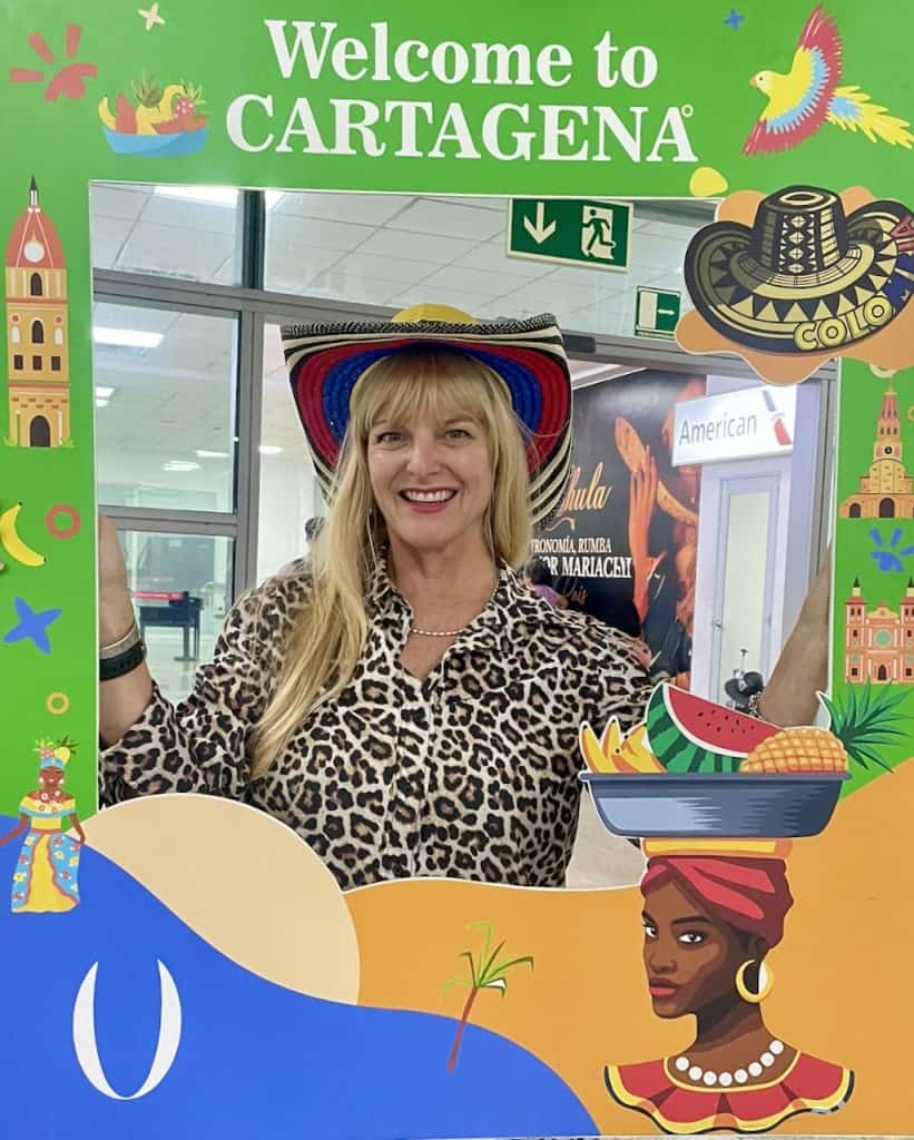 Cocameca founder Kate Dana smiles inside a large frame featuring Welcome to Cartagena ©Kate Dana