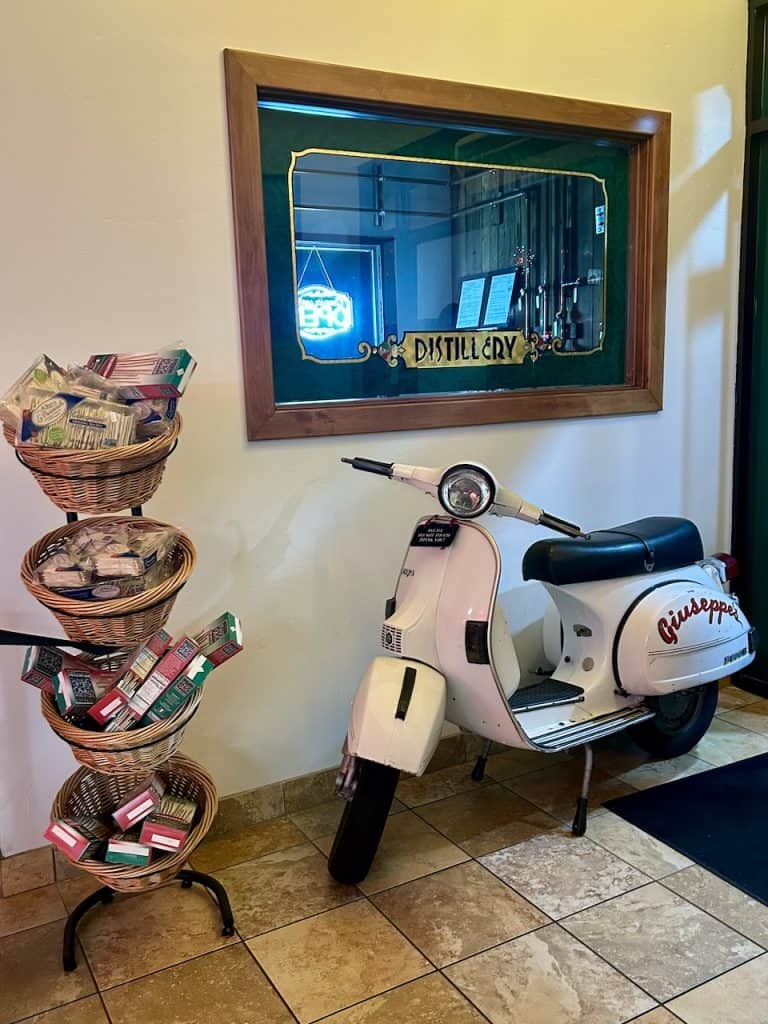 A white, vintage Vespa, Italian motor scooter, parked inside Giuseppe's Italian American Club in Pismo Beach, California