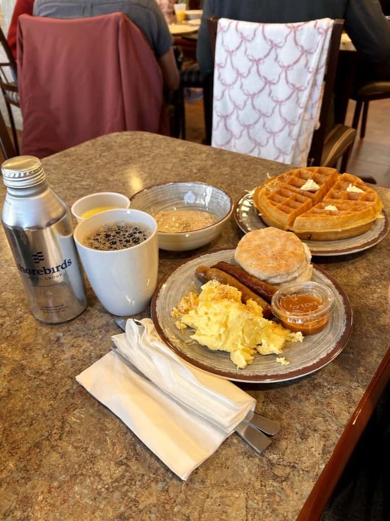 A table with breakfast food, eggs, waffles, biscuits, and coffee at Inn at the Cove near Pismo Beach, CA