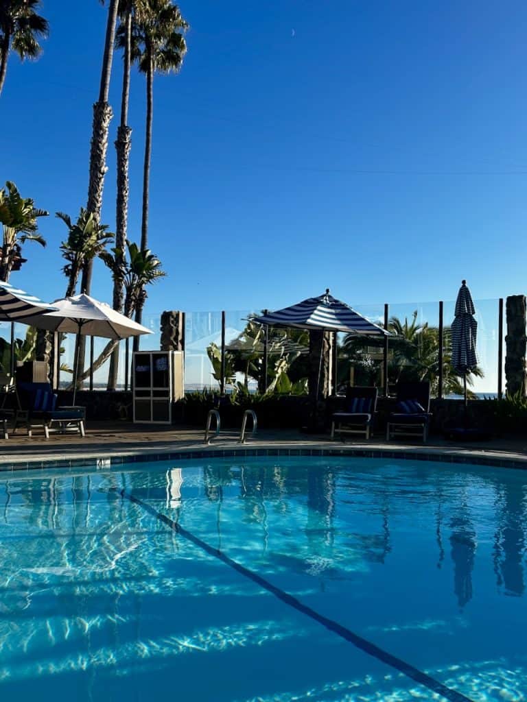 A shimmering blue pool beneath palm trees at Inn at the Cove near Pismo Beach, California