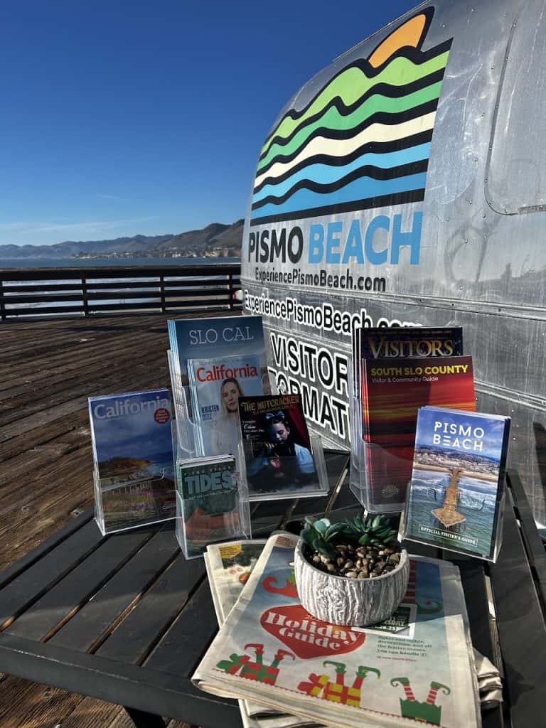 A silver Airstream trailer offering tourist information welcomes visitors to the pier in Pismo Beach, California