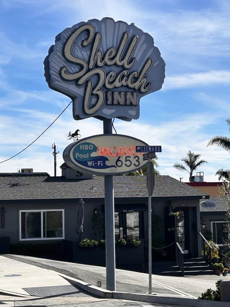 A vintage neon sign shaped like a shell announces Shell Beach Inn, California