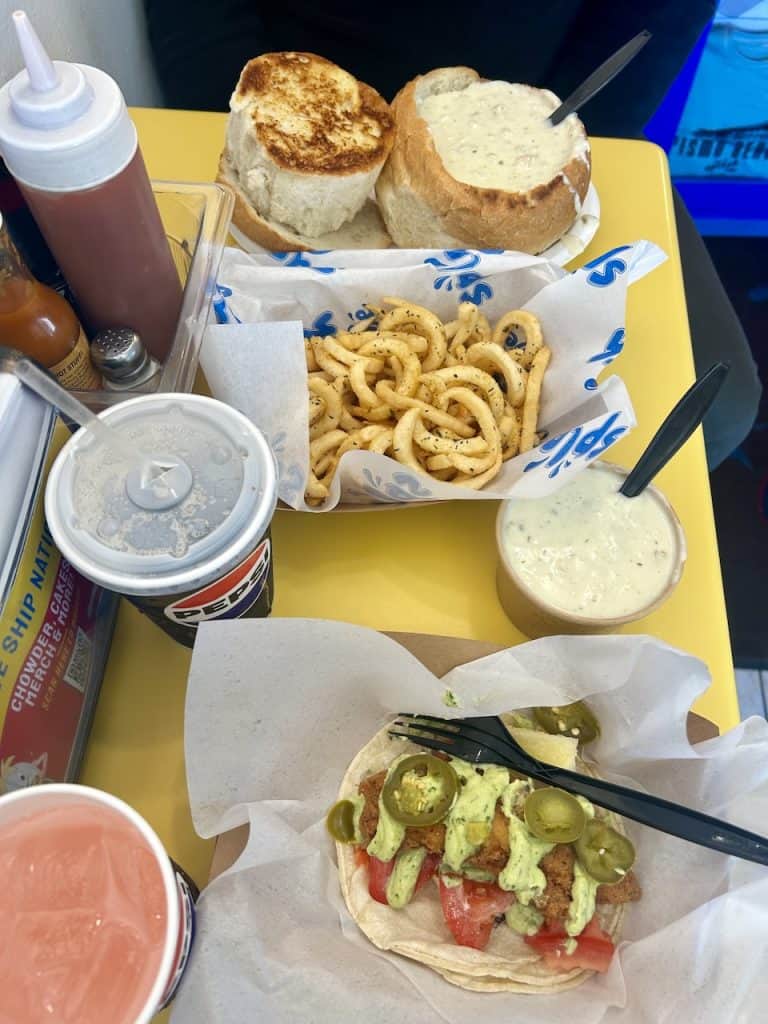 A bright yellow table shows clam chowder and other dishes at Splash Cafe, Pismo Beach, CA