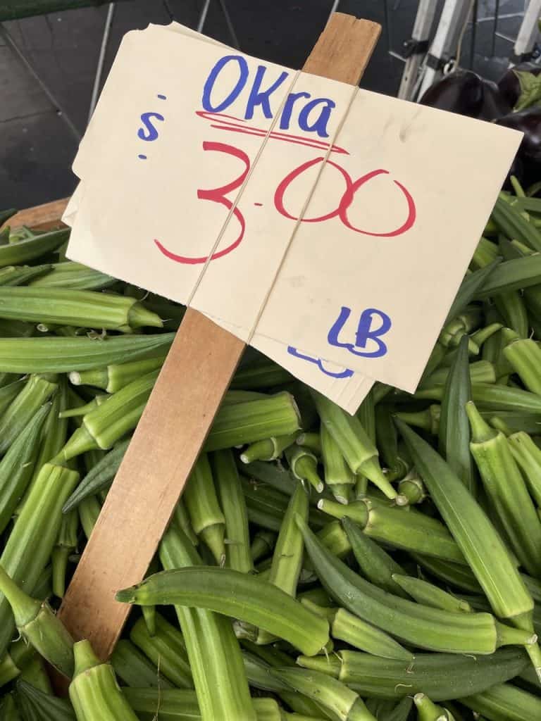 A sign shows fresh, green okra for sale at $3.00 a pound, photo ©Kate Dana