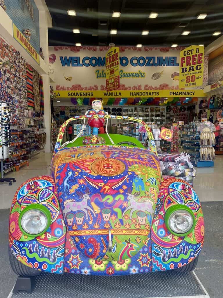A colorful Volkswagen beetle in the storefront of a souvenir shop on Isla Cozumel, Mexico, photo ©Kate Dana