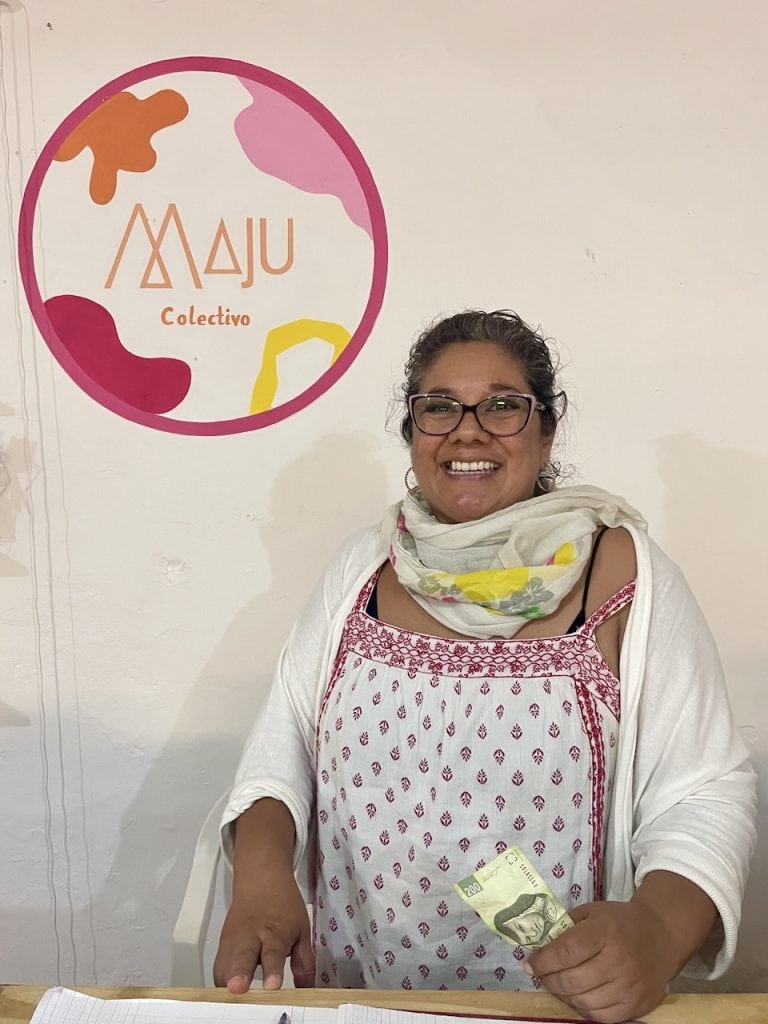 A smiling merchant at the counter inside Maju Colectivo artists in Cozumel, Mexico, photo ©Kate Dana