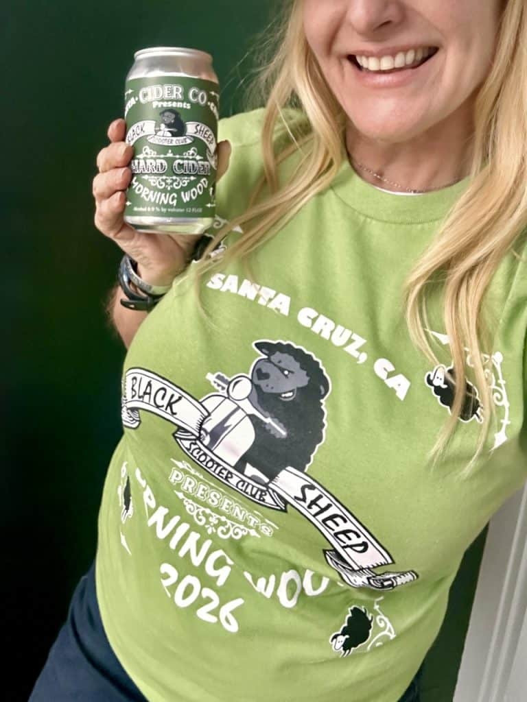 All smiles while holding a cider can and wearing a green Black Sheep Scooter Club Morning Wood Vintage Rally t-shirt in Watsonville, CA, photo ©Kate Dana