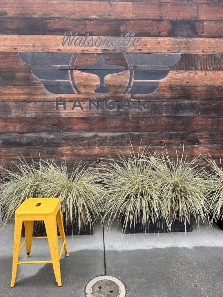 A wooden sign with an aviation theme announces The Hangar in Watsonville, CA, photo ©Kate Dana