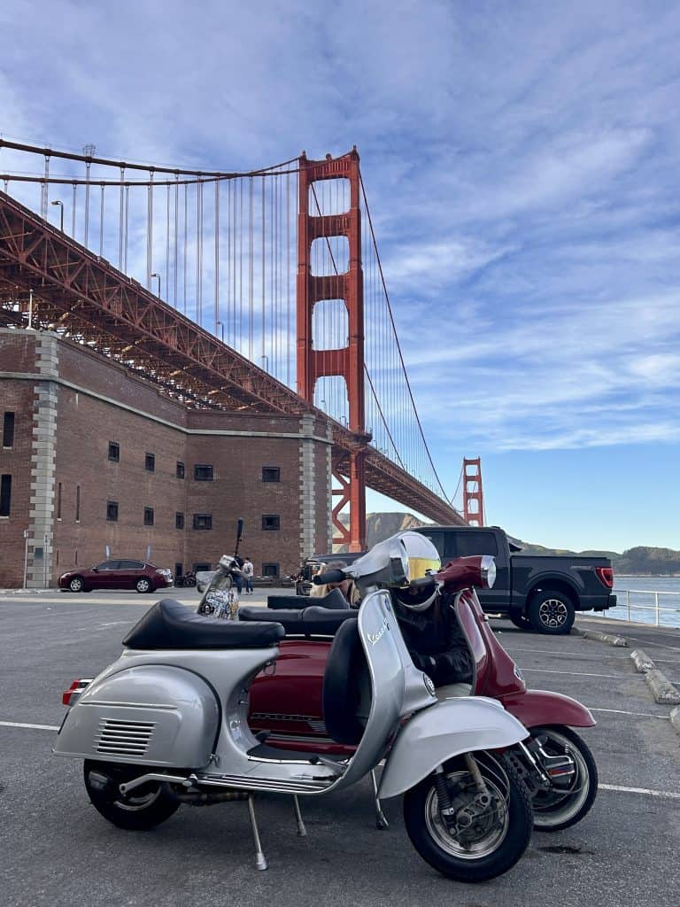 A vintage Vespa and Lambretta parked beneath the Golden Gate Bridge in San Francisco, California, photo ©Kate Dana