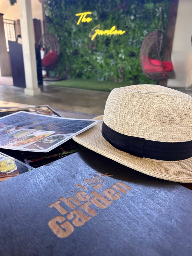 A table with a menu, hat and postcard at a stylish restaurant, photo ©Kate Dana