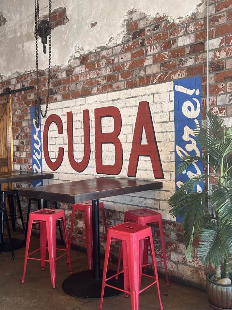 A large mural wall inside the eatery Cubanissimo announces, "CUBA" in red and white letters, photo ©Kate Dana