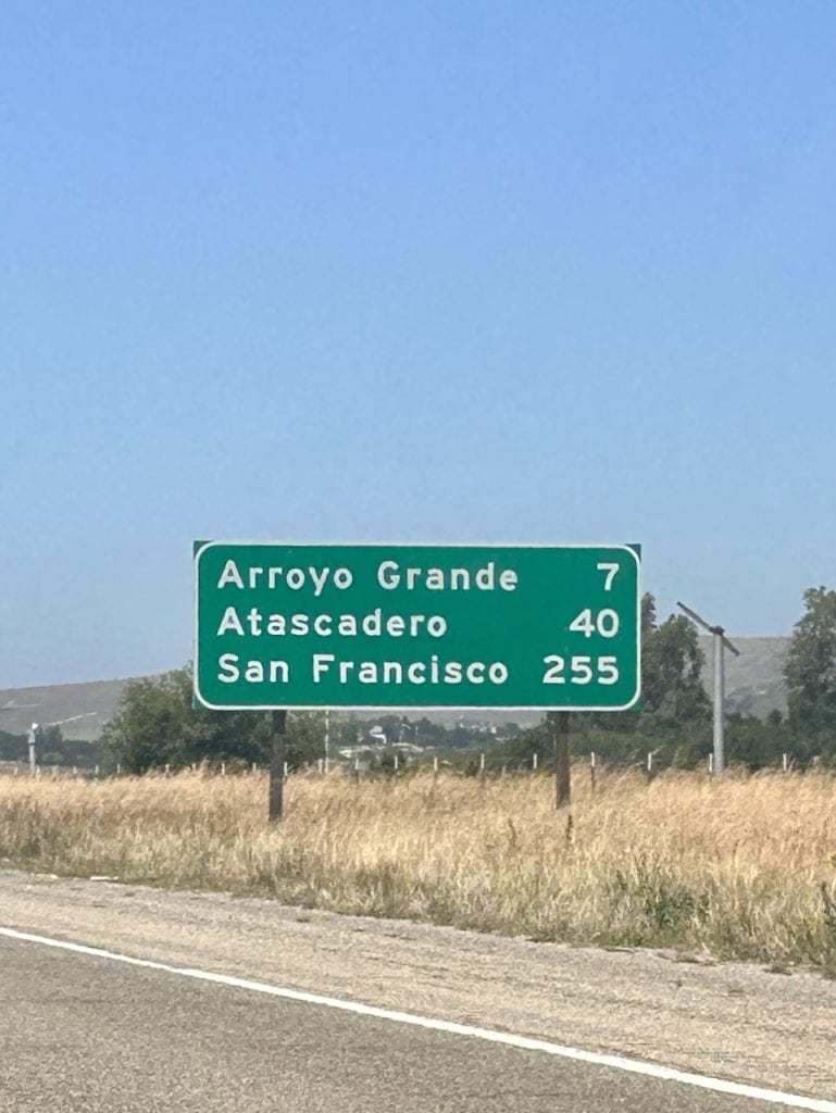A green and white sign announces the distance to San Francisco on the Central Coast, photo ©Kate Dana