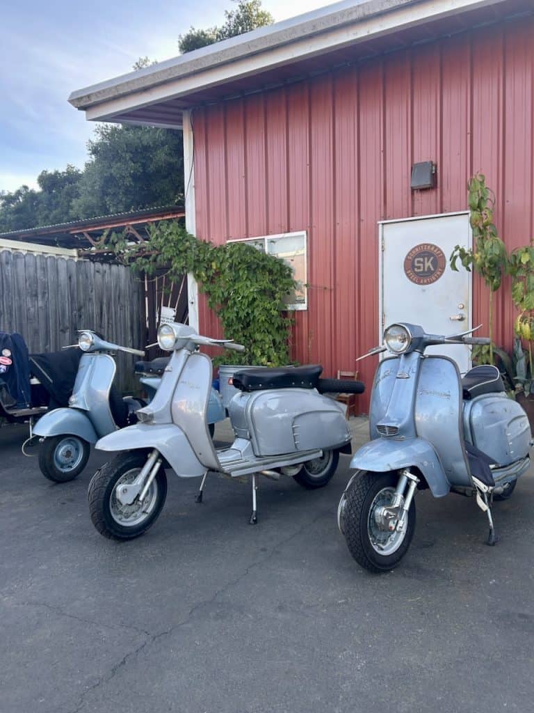 Several silver-colored, vintage Lambretta scooters parked together in Santa Rosa, California, photo ©Kate Dana