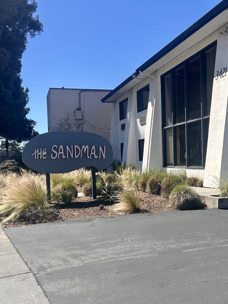 A view of the front entrance and a sign to the Sandman hotel in Santa Rosa, California, photo ©Kate Dana